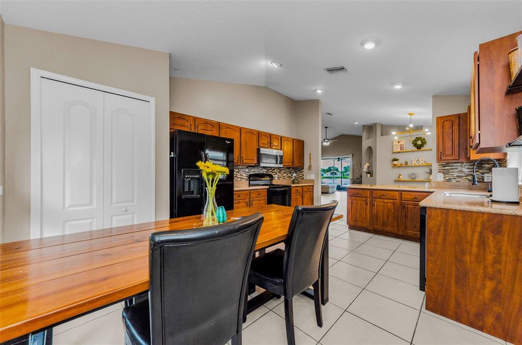13561 Fladgate Mark Drive Riverview, FL 33579 - Photo 20 of 65 a kitchen with stainless steel appliances a refrigerator a sink dishwasher with a dining table and chairs