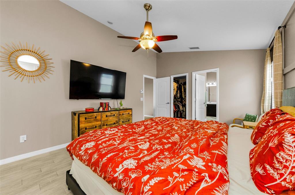 13561 Fladgate Mark Drive Riverview, FL 33579 - Photo 23 of 65 a bedroom with a bed and a flat screen tv