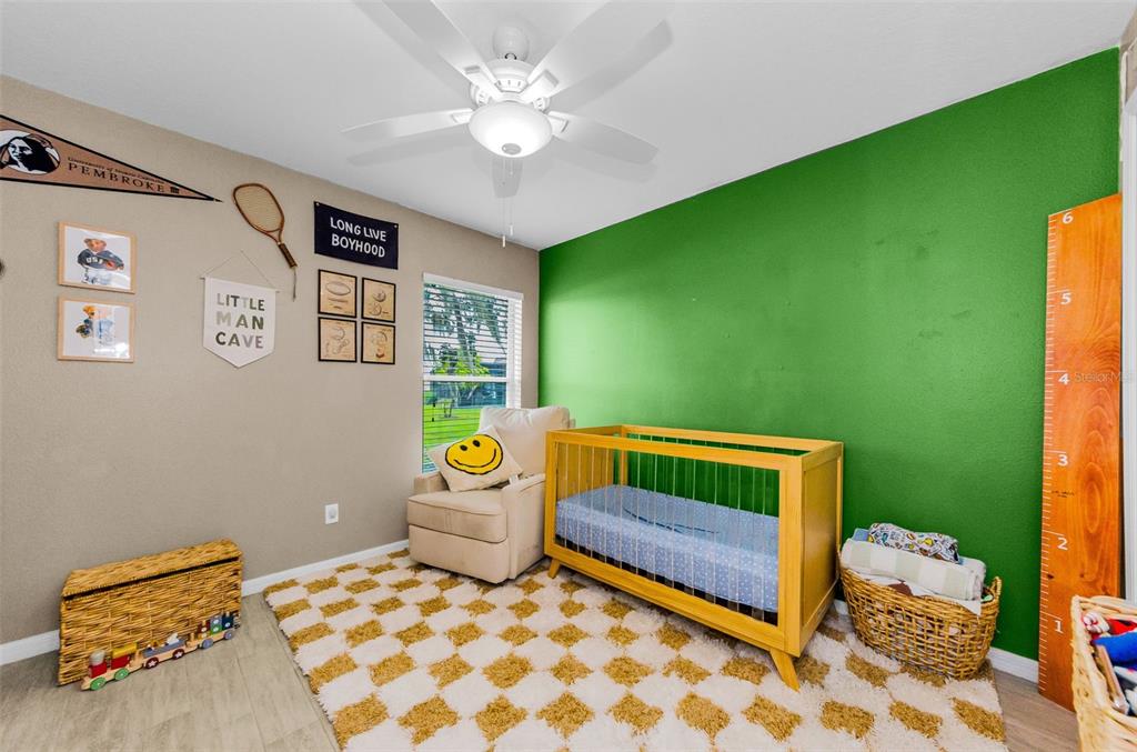 13561 Fladgate Mark Drive Riverview, FL 33579 - Photo 28 of 65 a bedroom with a bed and a chandelier