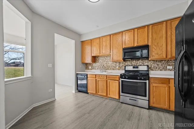 a kitchen with stainless steel appliances granite countertop a stove a sink and a microwave