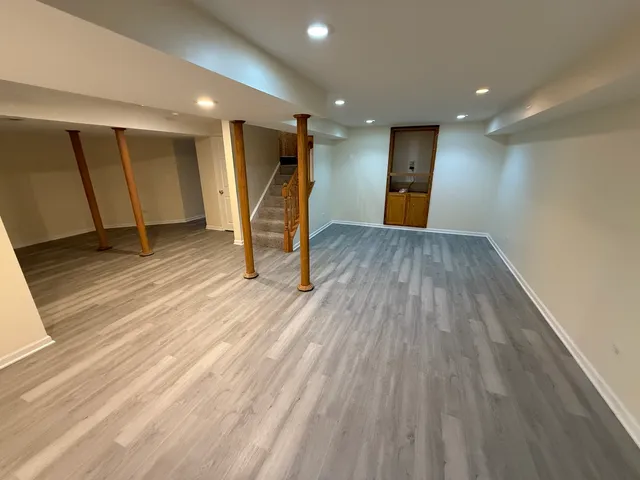 a view of a room with wooden floor and a window