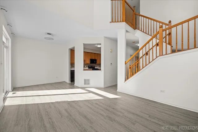 a view of a hallway with wooden floor and staircase