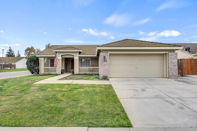 a front view of a house with a yard and garage