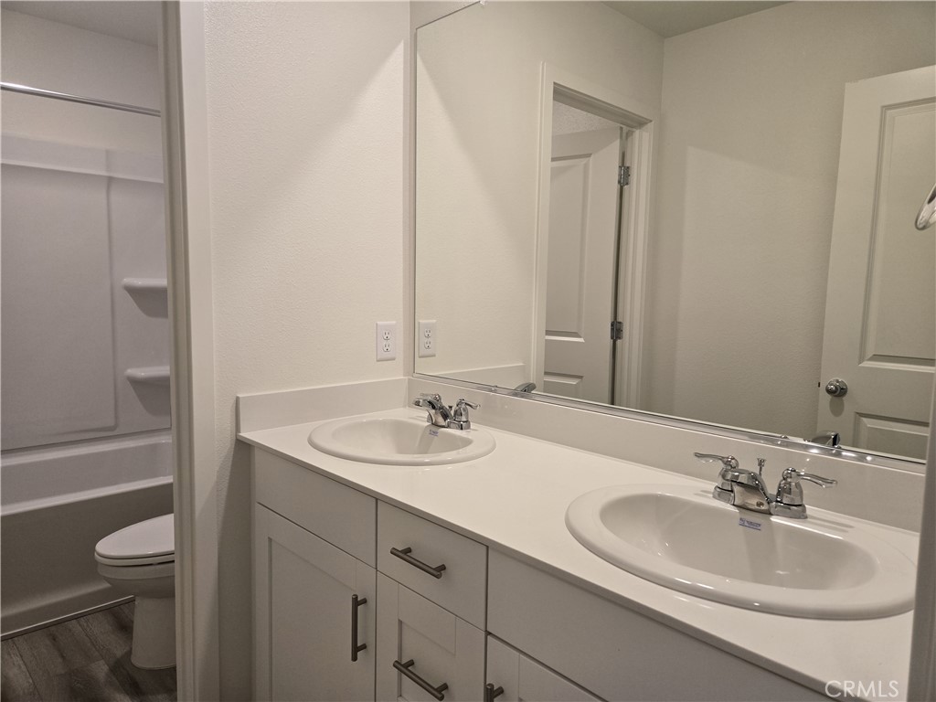 959 Pico Place Chico, CA 95973 - Photo 13 of 19 a bathroom with a granite countertop sink toilet and a mirror