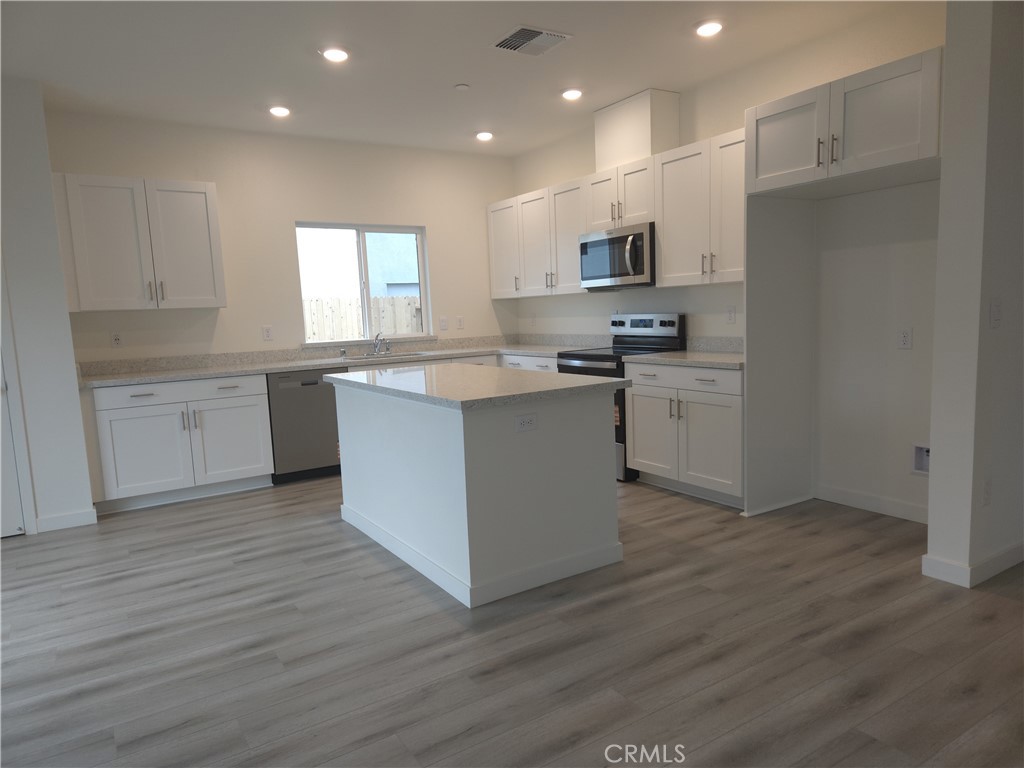 959 Pico Place Chico, CA 95973 - Photo 6 of 19 a kitchen with stainless steel appliances granite countertop a stove top oven a sink dishwasher and a refrigerator with wooden floor