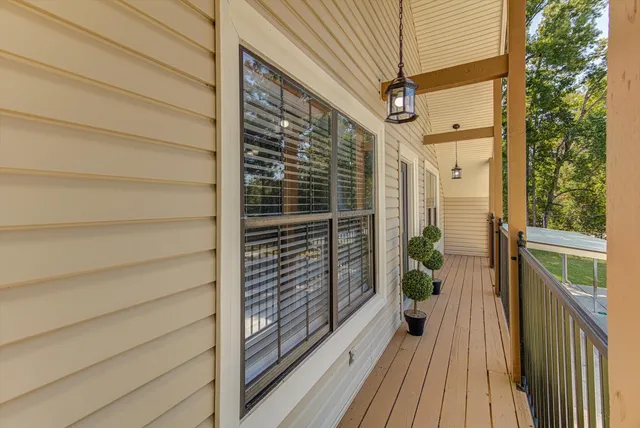 a view of a balcony with wooden floor and fence