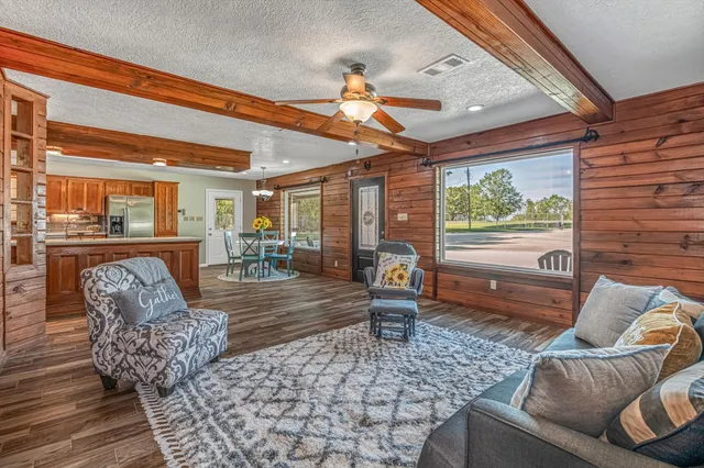 a dining room with wooden floor a chandelier a glass table and chairs
