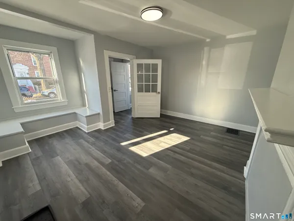 wooden floor in an empty room with a window