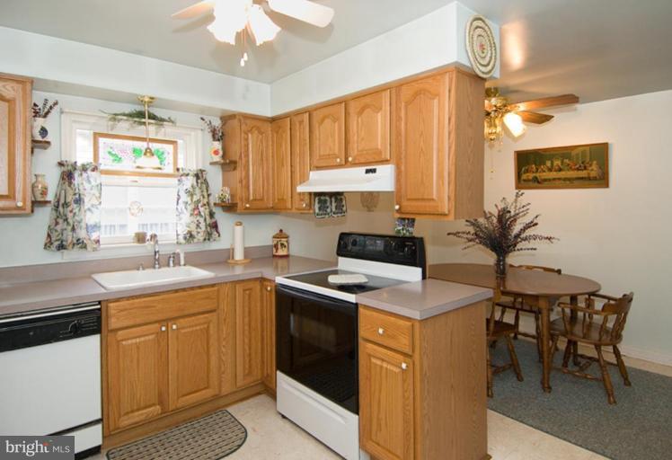 508 Grovethorn Road Middle River, MD 21220 - Photo 7 of 19 a kitchen with a stove a sink a dining table and chairs
