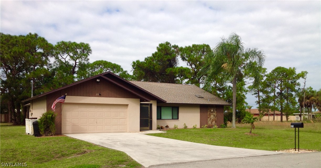 25 Michigan Road Lehigh Acres, FL 33936 - Photo 1 of 16 a front view of a house with garden