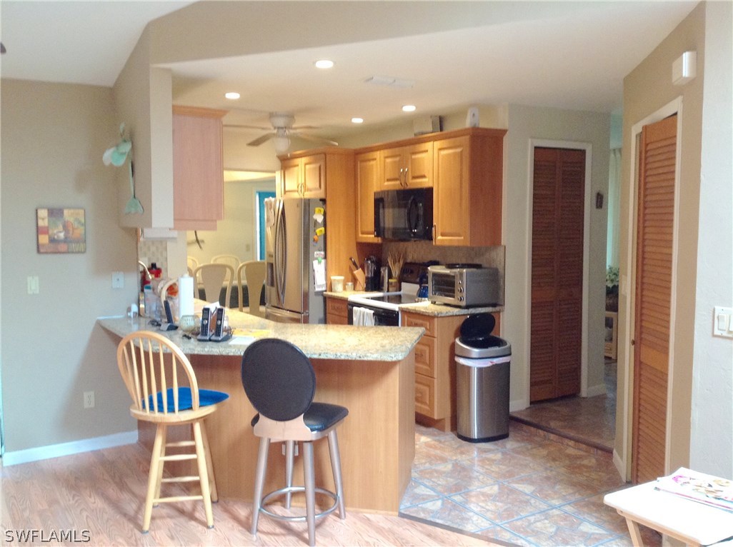 25 Michigan Road Lehigh Acres, FL 33936 - Photo 8 of 16 a kitchen with a dining table chairs and refrigerator