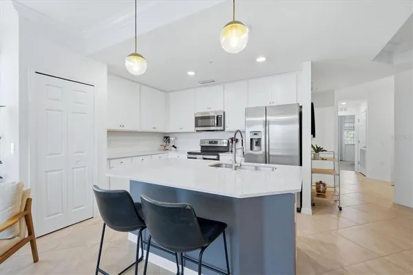 a kitchen with refrigerator and chairs