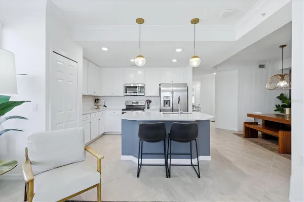 a living room with kitchen island furniture and a chandelier
