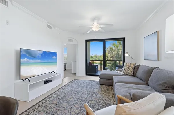 a living room with furniture a flat screen tv and a floor to ceiling window