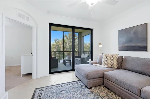 a bedroom with a large bed couch and a large window