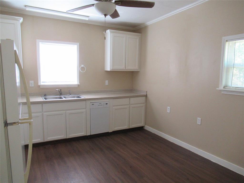 1402 Walnut Street Commerce, TX 75428 - Photo 12 of 12 a view of a kitchen with a sink hardwood floor and a window