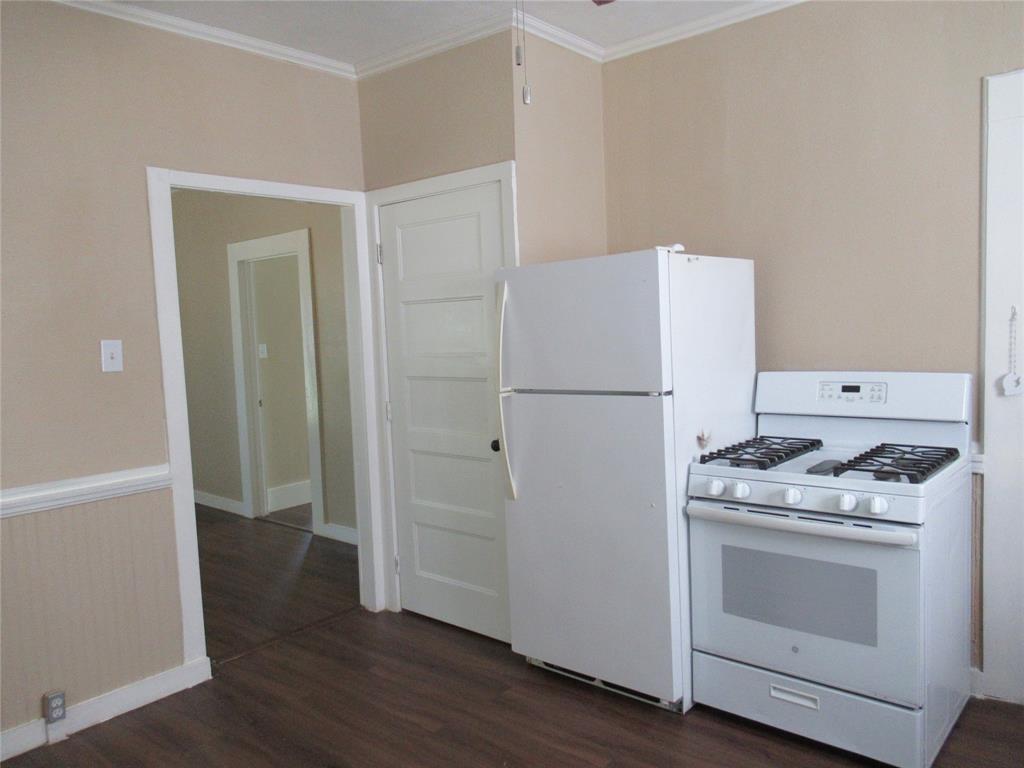 1402 Walnut Street Commerce, TX 75428 - Photo 5 of 12 a kitchen with a stove top oven and refrigerator