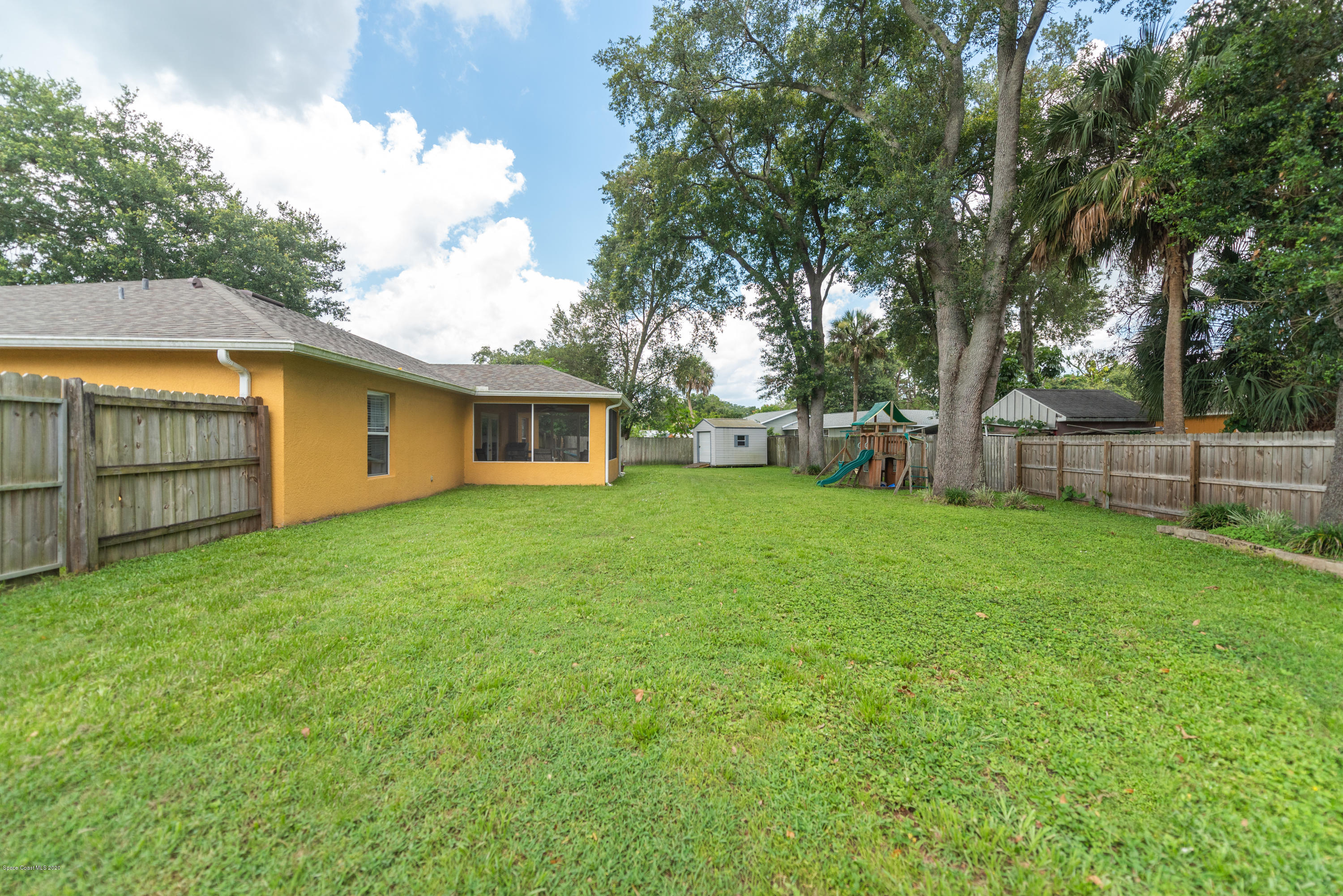 6040 Adina Road Cocoa, FL 32927 - Photo 22 of 23 a view of a backyard with a garden and tree