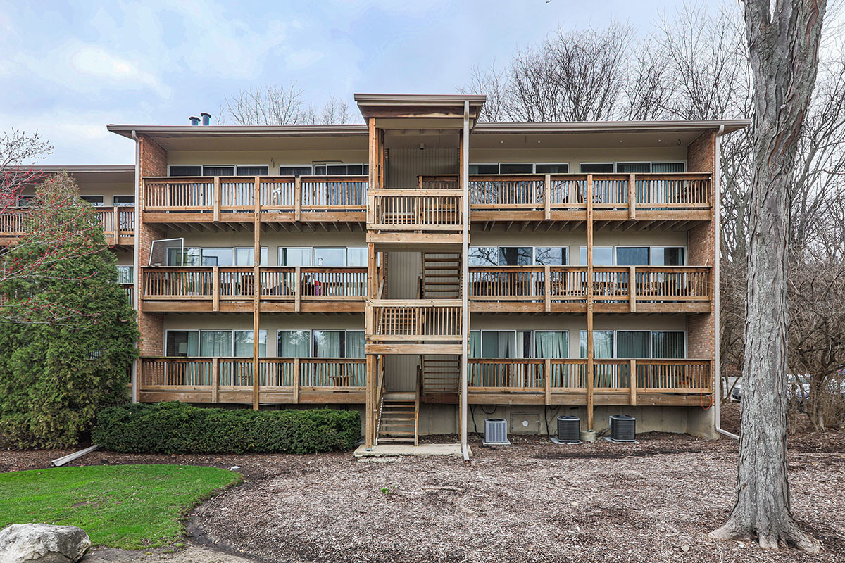 5852 Forest View Road, Unit E Lisle, IL 60532 - Photo 1 of 21 a large building with a yard and a large window
