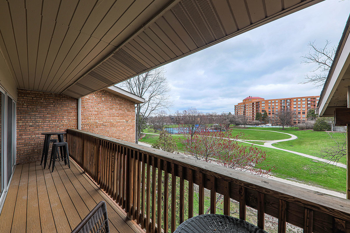 5852 Forest View Road, Unit E Lisle, IL 60532 - Photo 17 of 21 a balcony with wooden floor outdoor seating and yard in the back