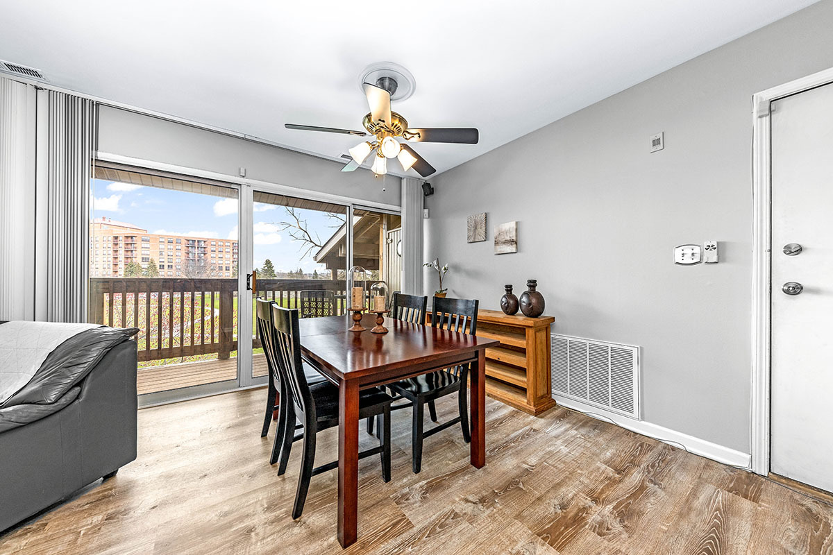 5852 Forest View Road, Unit E Lisle, IL 60532 - Photo 3 of 21 a dining room with furniture a chandelier and wooden floor