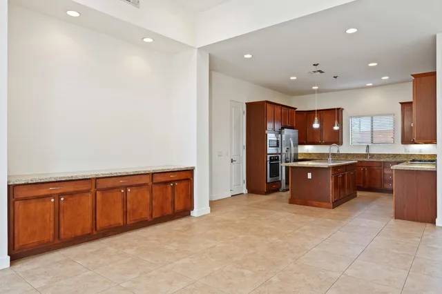 a kitchen with stainless steel appliances granite countertop a sink refrigerator and cabinets