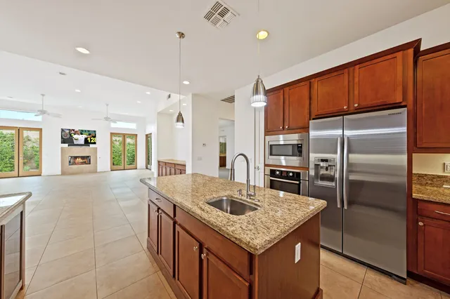a kitchen with stainless steel appliances granite countertop a sink refrigerator and cabinets