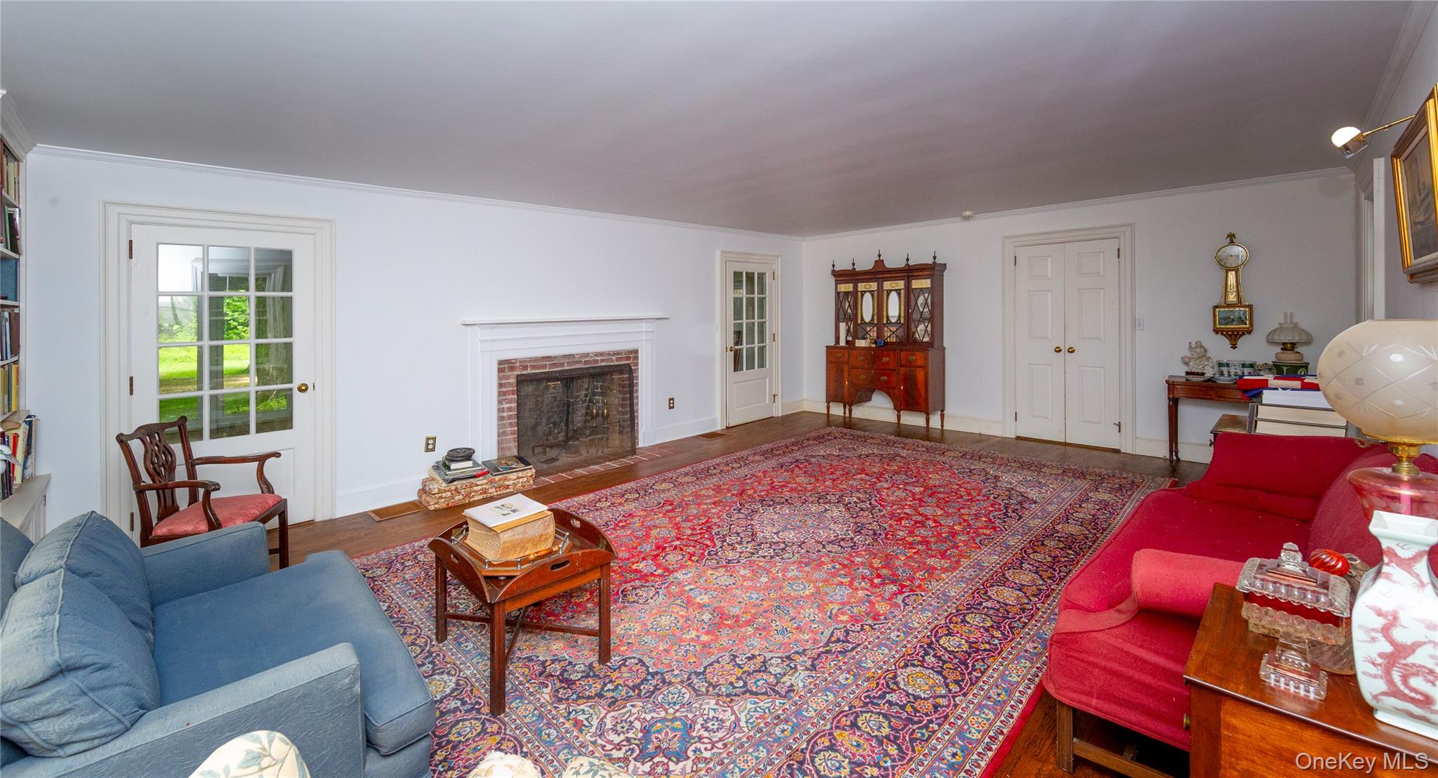 64 South Quaker Hill Road Pawling, NY 12564 - Photo 17 of 41 Spacious room featuring wood-finish flooring, a brick fireplace with a white mantel, and built-in shelving
