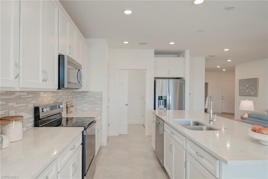 5686 Mayflower Way, Unit 702 Ave Maria, FL 34142 - Photo 14 of 50 Kitchen with stainless steel appliances, recessed lighting, white cabinets, quartz countertops and pull out shelves!