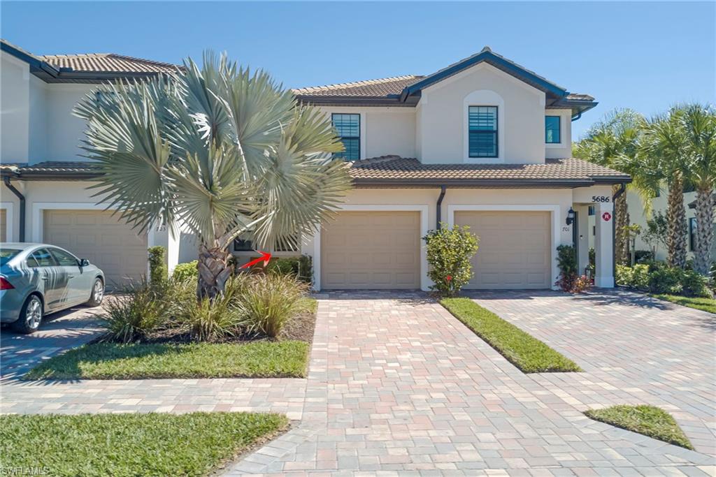 5686 Mayflower Way, Unit 702 Ave Maria, FL 34142 - Photo 3 of 50 Mayflower "Egret" Model #702 Front of house featuring decorative driveway, an attached garage, stucco siding, and a tile roof