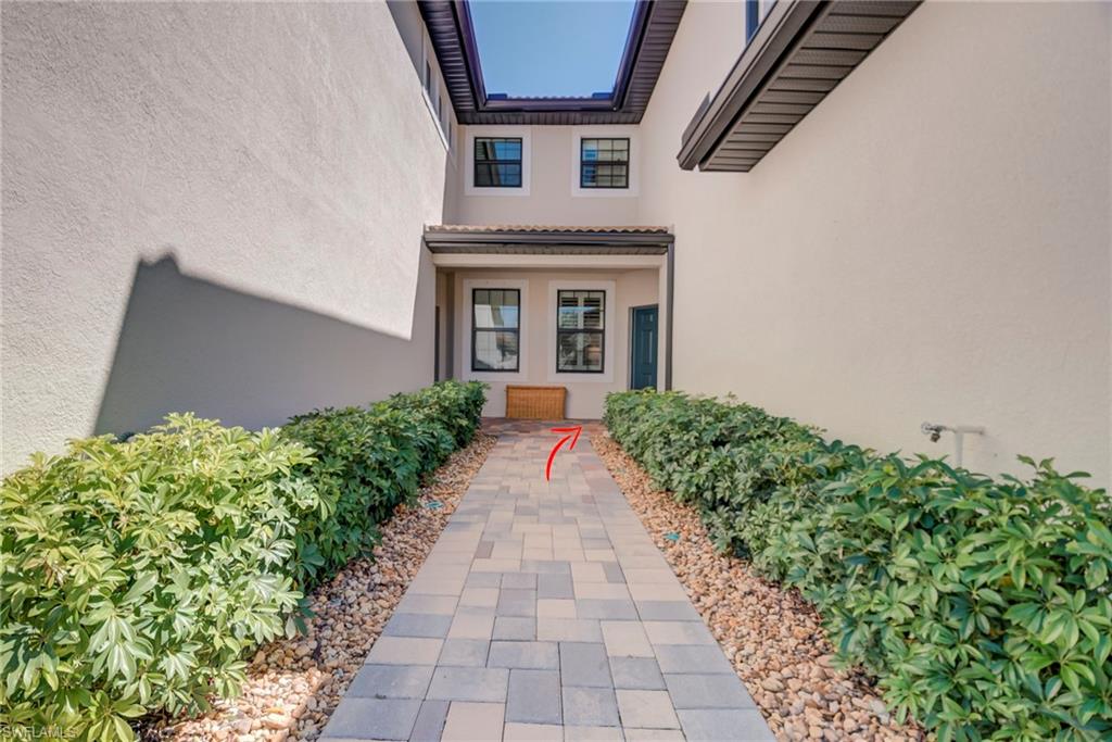 5686 Mayflower Way, Unit 702 Ave Maria, FL 34142 - Photo 6 of 50 View of shared walk-way to entry featuring stucco siding