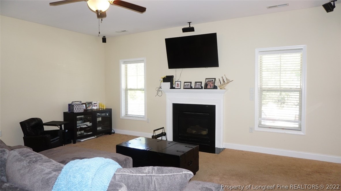 115 Shellbark Drive Spring Lake, NC 28390 - Photo 7 of 30 a living room with furniture a fireplace and a flat screen tv