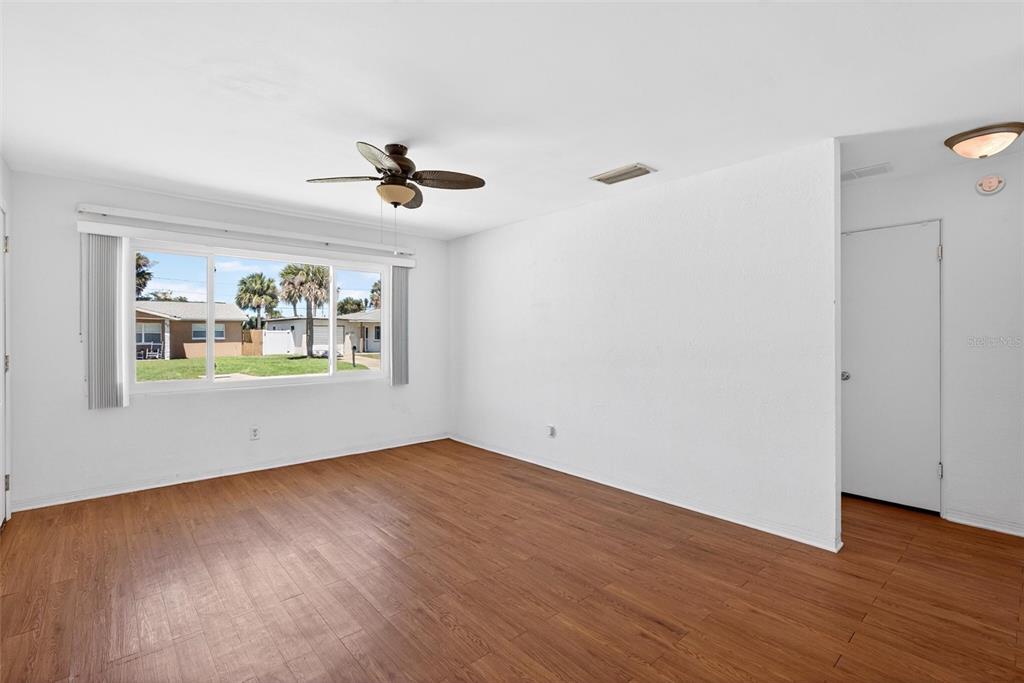 47 Carol Road Ormond Beach, FL 32176 - Photo 4 of 54 an empty room with wooden floor chandelier fan and windows