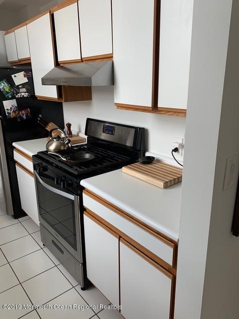 40 Broad Street, Unit 3A Red Bank, NJ 07701 - Photo 4 of 10 a kitchen with stainless steel appliances granite countertop a stove and a microwave