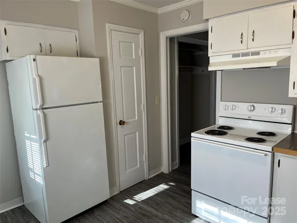a kitchen with granite countertop white cabinets and white appliances
