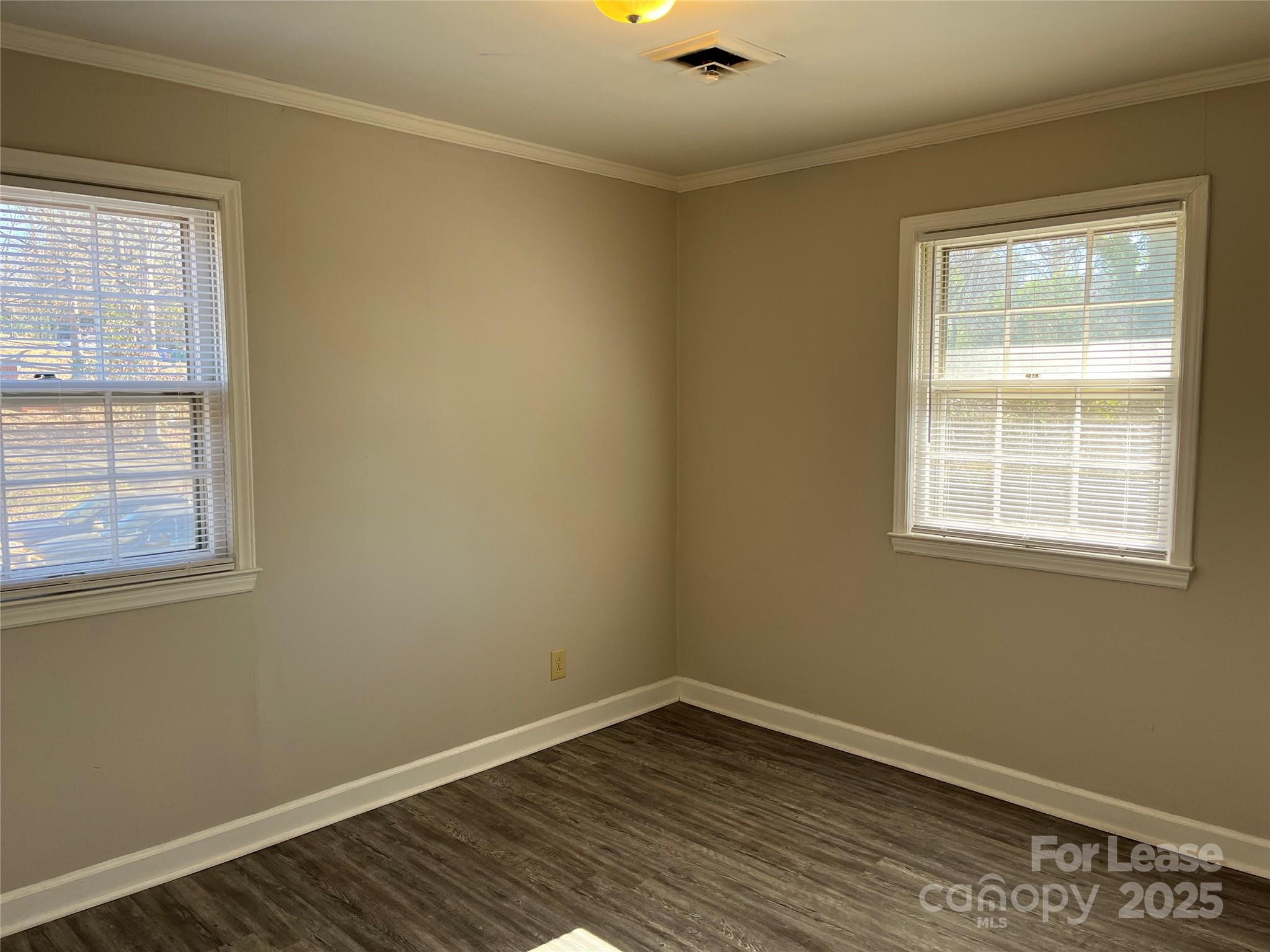 600 Montgomery Avenue, Unit 3 Albemarle, NC 28001 - Photo 7 of 9 an empty room with wooden floor and windows