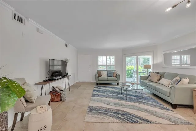 a living room with furniture a flat screen tv and a large window