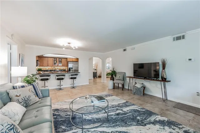a bedroom with a bed a chandelier and a flat screen tv