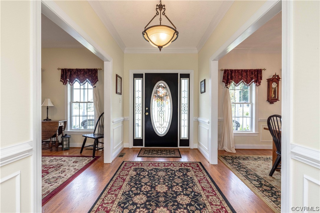 16211 River Road Chesterfield, VA 23838 - Photo 6 of 40 a view of a hallway with wooden floor potted plant and a chandelier