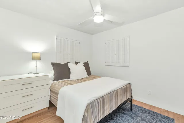 a bedroom with a bed and painting on the wall