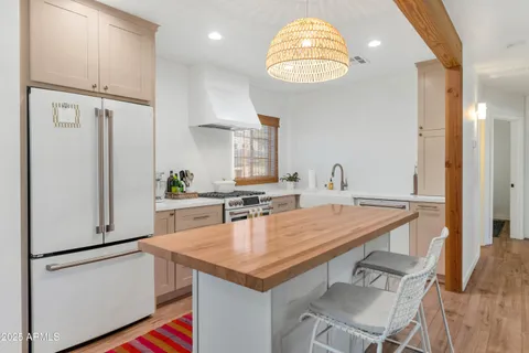 a kitchen with stainless steel appliances granite countertop a table chairs and a refrigerator