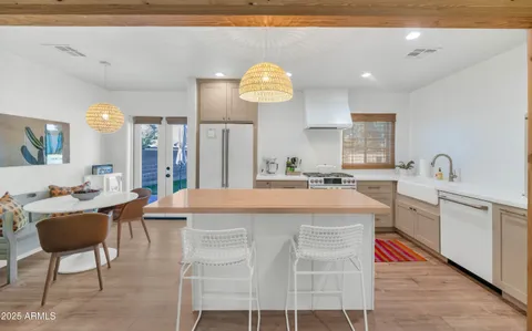 a large kitchen with kitchen island stainless steel appliances a table and chairs