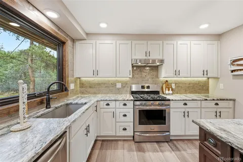 a kitchen with a stove sink and cabinets