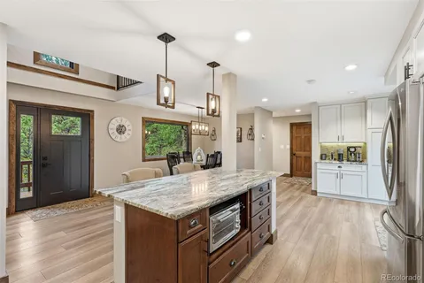 a kitchen with kitchen island wooden floor center island and stainless steel appliances