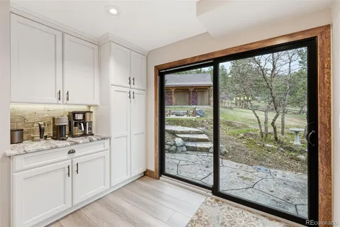 a kitchen with white cabinets and a wooden floor