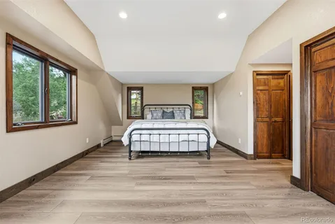 a bedroom with a bed and wooden floor