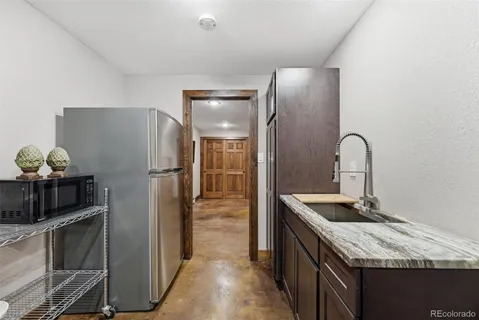 a kitchen with granite countertop a refrigerator and a sink