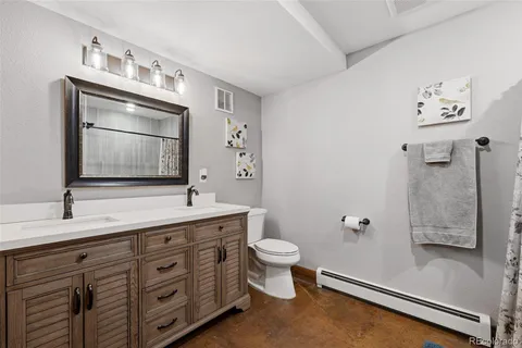 a bathroom with a double vanity sink toilet mirror and bathtub