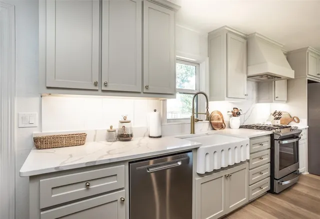 a kitchen with stainless steel appliances granite countertop a sink stove and cabinets