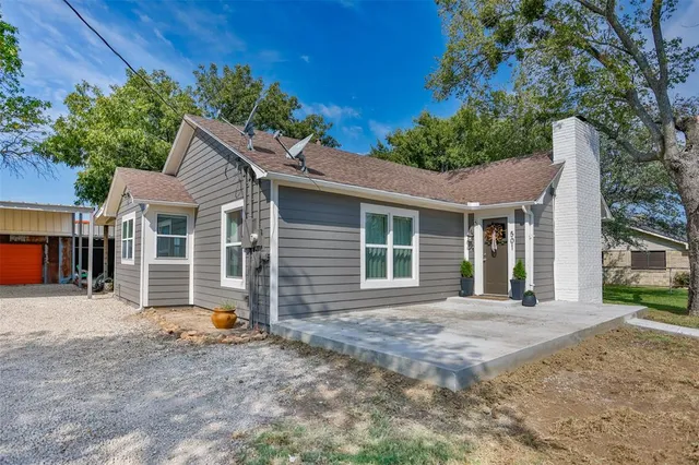 a front view of a house with a yard and potted plants
